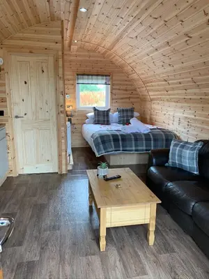 a room with a bed and a couch and a table at Pond View Pod 3 With Private Hot Tub -Fife - Loch Leven - Lomond Hills in Kelty