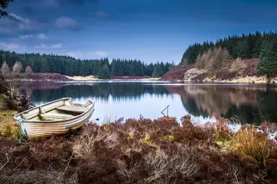 a boat sitting on the shore of a lake at Kinloch Hotel, Isle of Arran in Blackwaterfoot
