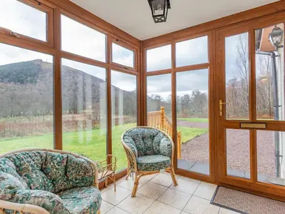 a room with two chairs and a large window at Bidean Lodge in Glencoe