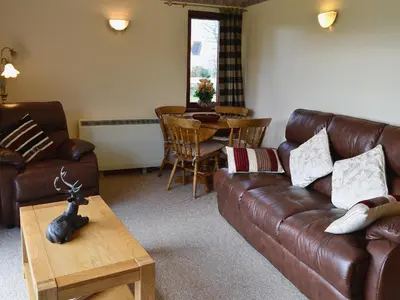 a living room with a leather couch and a table at Duart in Onich
