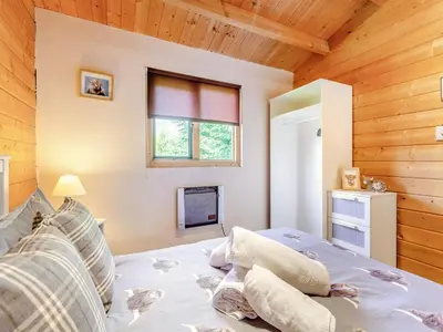 a bedroom with a bed in a room with wooden walls at The Willows in Glencoe