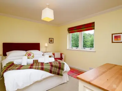 a bedroom with a bed and a window at Carness West in North Ballachulish