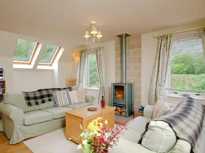 a living room with two couches and a fireplace at Carness West in North Ballachulish