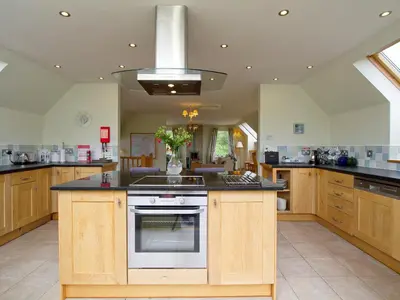 a large kitchen with wooden cabinets and a stove at Carness West in North Ballachulish