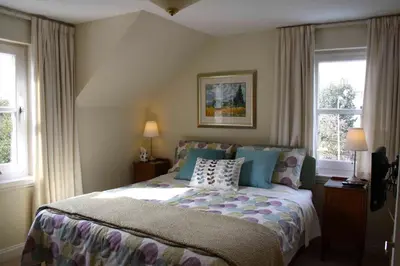 a bedroom with a bed and two windows at Balmillig B&B in Helensburgh