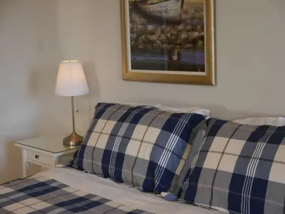 a bed with two blue and white pillows and a lamp at Balmillig B&B in Helensburgh