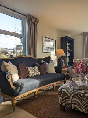 a living room with a blue couch and a window at The Posting House in Kilchrenan