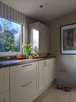 a kitchen with white cabinets and a window at The Posting House in Kilchrenan