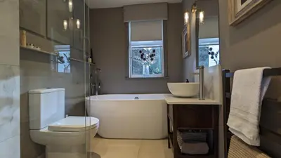 a bathroom with a tub and a toilet and a sink at The Posting House in Kilchrenan
