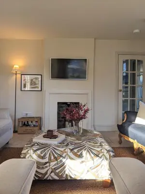 a living room with a table and a fireplace at The Posting House in Kilchrenan
