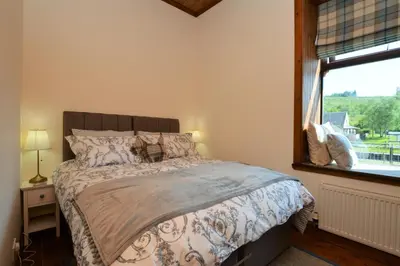 a bedroom with a large bed and a window at Cairnbaan House in Cairnbaan