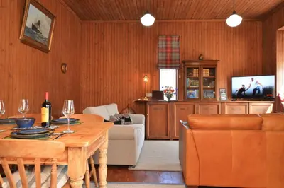 a living room with a table and a couch at Cairnbaan House in Cairnbaan