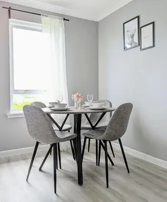 a dining room table with four chairs and a window at Campbeltown View in Campbeltown