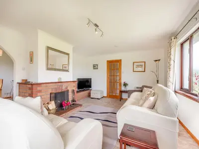 a living room with white furniture and a fireplace at Glenview in Appin