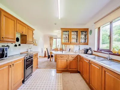 a large kitchen with wooden cabinets and appliances at Glenview in Appin