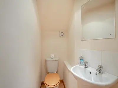 a bathroom with a toilet and a sink and a mirror at Stonefield Farm Cottage in Benmore