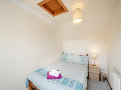 a small bedroom with a bed and a lamp at Stonefield Farm Cottage in Benmore
