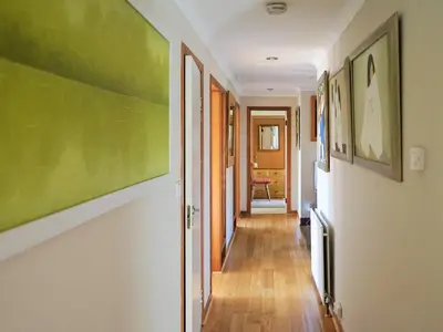 a hallway with paintings on the walls of a house at Rosmuire in Rhu