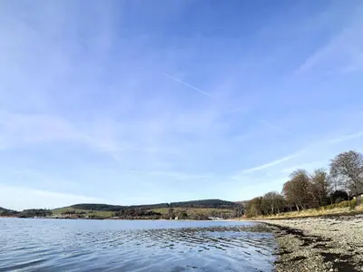 a kite flying over a body of water at Rosmuire in Rhu