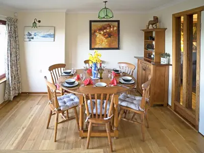 a wooden table with chairs and a dining room at Rosmuire in Rhu