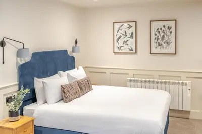 a bedroom with a large white bed with pillows at Grove House Hotel in Edinburgh