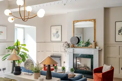 a living room with a fireplace and a mirror at Grove House Hotel in Edinburgh