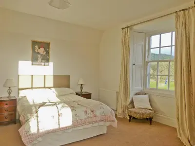 a bedroom with a bed and a window and a chair at The Factors House - 25752 in Kilmartin