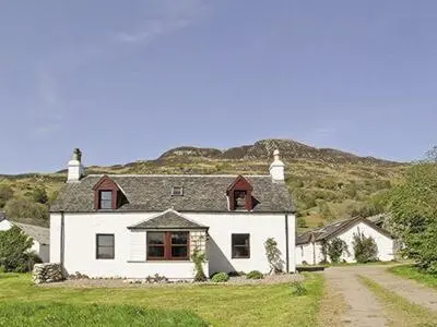 a large white house with a mountain in the background at Dalvuie Beag in Connel