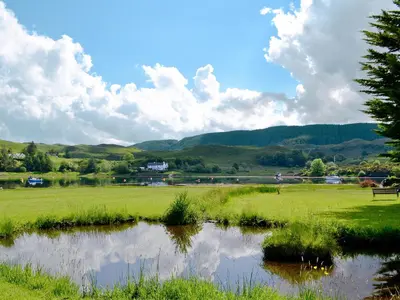 a pond in the middle of a grassy field at Torsa - 28790 in Clachan
