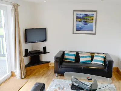 a living room with a leather couch and a tv at Lunga - 28791 in Clachan