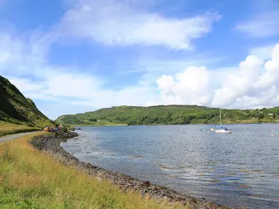 a boat is sitting on the water next to the shore at Ardbhan Croft in Oban
