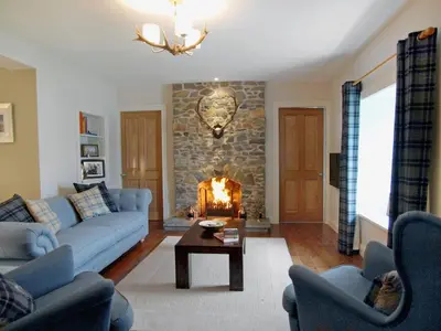 a living room with a couch and a fireplace at Ardbhan Croft in Oban
