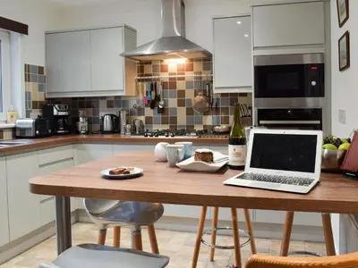 a kitchen with a table with a laptop on it at Tigh Raineach in Strathyre