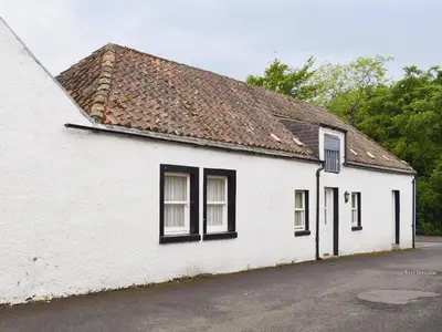 a white building with black windows and a roof at Inn Cottage in Glendevon