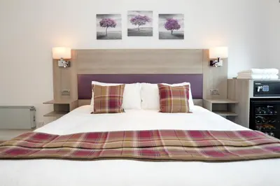 a bedroom with a large white bed with two pillows at Fyne Rooms in Tighnabruaich