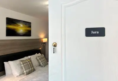 a white door with a sign that reads juana at Fyne Rooms in Tighnabruaich