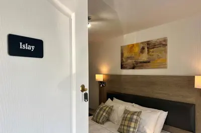 a bedroom with a bed and a sign that reads isley at Fyne Rooms in Tighnabruaich