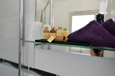 a glass shelf in a bathroom with a mirror at Fyne Rooms in Tighnabruaich