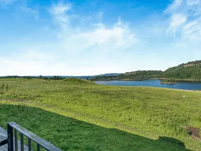 a view of a lake in a field with a fence at Kestrel Cottage - 27937 in Stirling