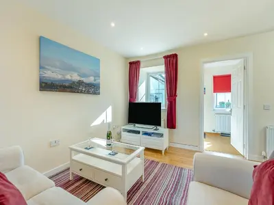 a living room with a couch and a tv at Kestrel Cottage - 27937 in Stirling