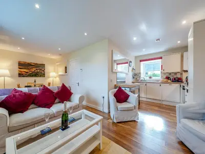 a living room with a couch and a table at Peregrine Cottage in Stirling