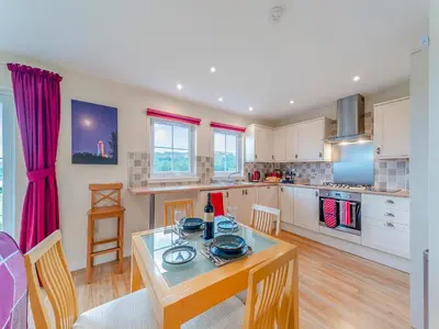 a kitchen with a table and chairs in a room at Osprey Cottage- 27939 in Stirling