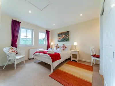 a bedroom with a bed and a chair and window at Osprey Cottage- 27939 in Stirling