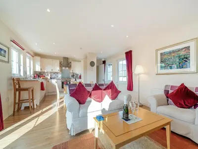 a living room with two white couches and a table at Buzzard Cottage - 27940 in Stirling