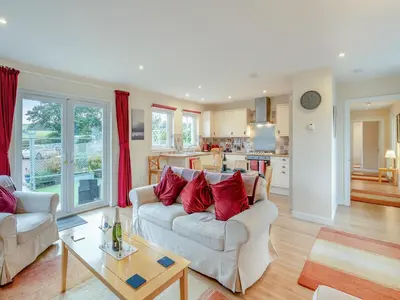 a living room with two couches and a kitchen at Barn Owl Cottage - 27941 in Stirling