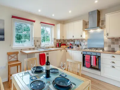 a kitchen with a table and chairs and a stove at Barn Owl Cottage - 27941 in Stirling