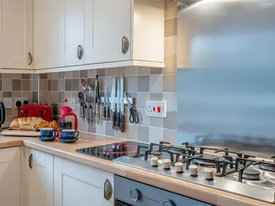a kitchen with a stove and a counter top at Barn Owl Cottage - 27941 in Stirling