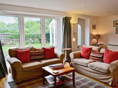 a living room with two couches and a table at Rathlin Coach House in Comrie