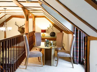 a dining room with a table and chairs at Fochy Cottage in Milnathort