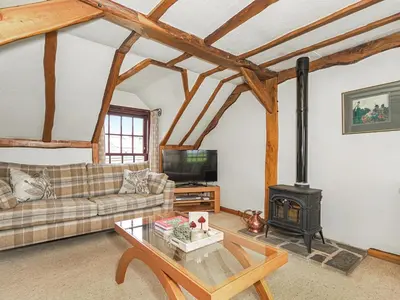 a living room with a couch and a wood stove at The Hayloft in Milnathort